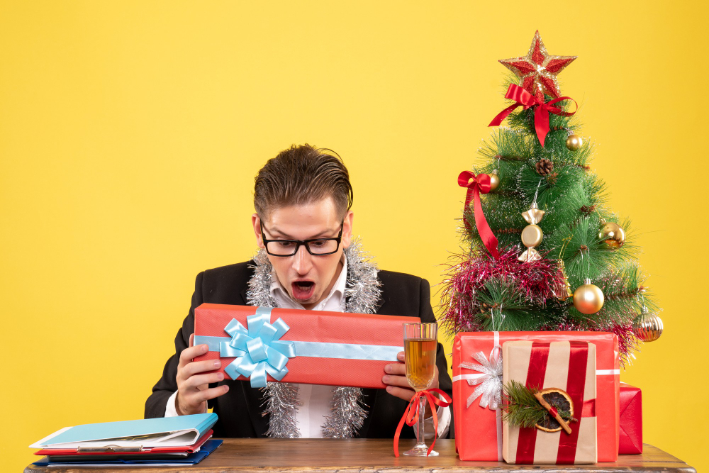 front-view-male-worker-sitting-holding-christmas-present (1)